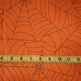 Halloween projects with this orange spider web fabric By Yard