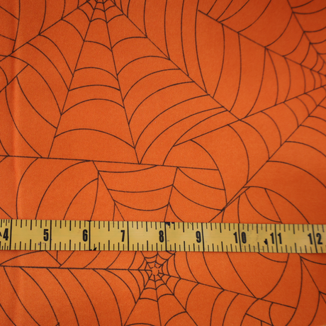 Halloween projects with this orange spider web fabric By Yard