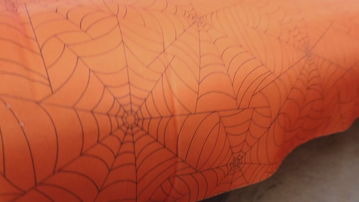Halloween projects with this orange spider web fabric By Yard